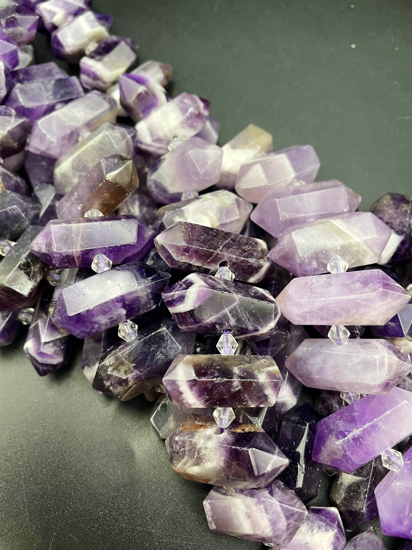 AAA Natural Amethyst stone bead. 12x26-12x34mm graduated barrel shape. Gorgeous natural purple color with white lines. Full strand 15.5”