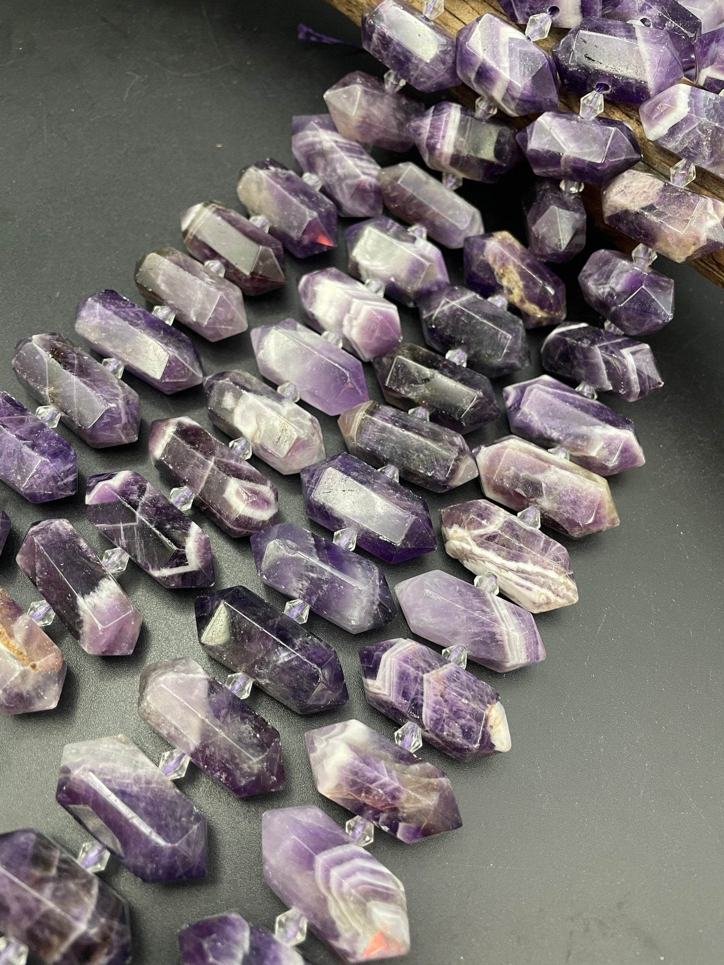 AAA Natural Amethyst stone bead. 12x26-12x34mm graduated barrel shape. Gorgeous natural purple color with white lines. Full strand 15.5”